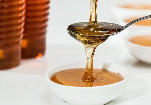 Honey is poured onto a spoon.