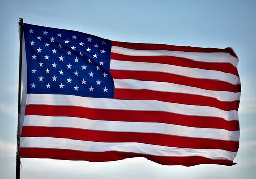 An American flag waves on a flag pole.