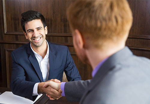 Businessman shaking hands with another businessman selling insurance