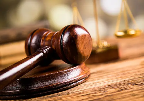 A judge's gavel rests on a desk.