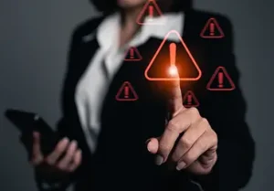 A businesswoman points at an alert symbol.