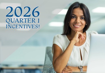 A woman smiles and sits at her desk.