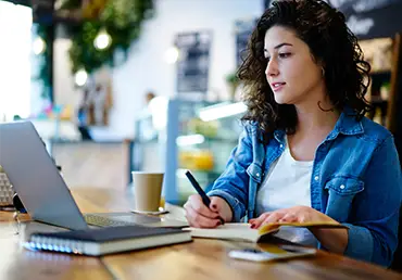 A young woman watches a webinar on her laptop.