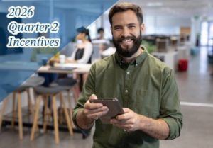 A man smiles at the camera while holding a tablet.