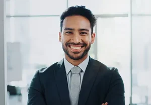 Portrait, smile man in office for corporate career or job in suit at company. Face, happy professional and confident insurance agent or entrepreneur with arms crossed at work in