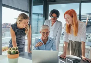 A group of females employees assist a new employee.