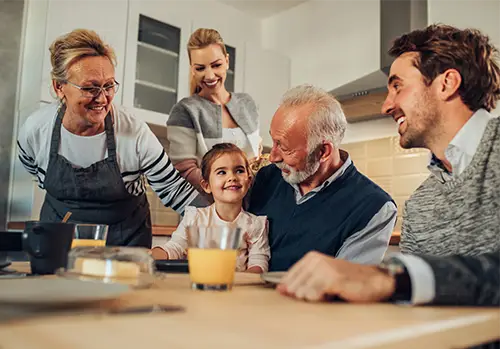 A Family gathered together in a dining room, eating breakfast.